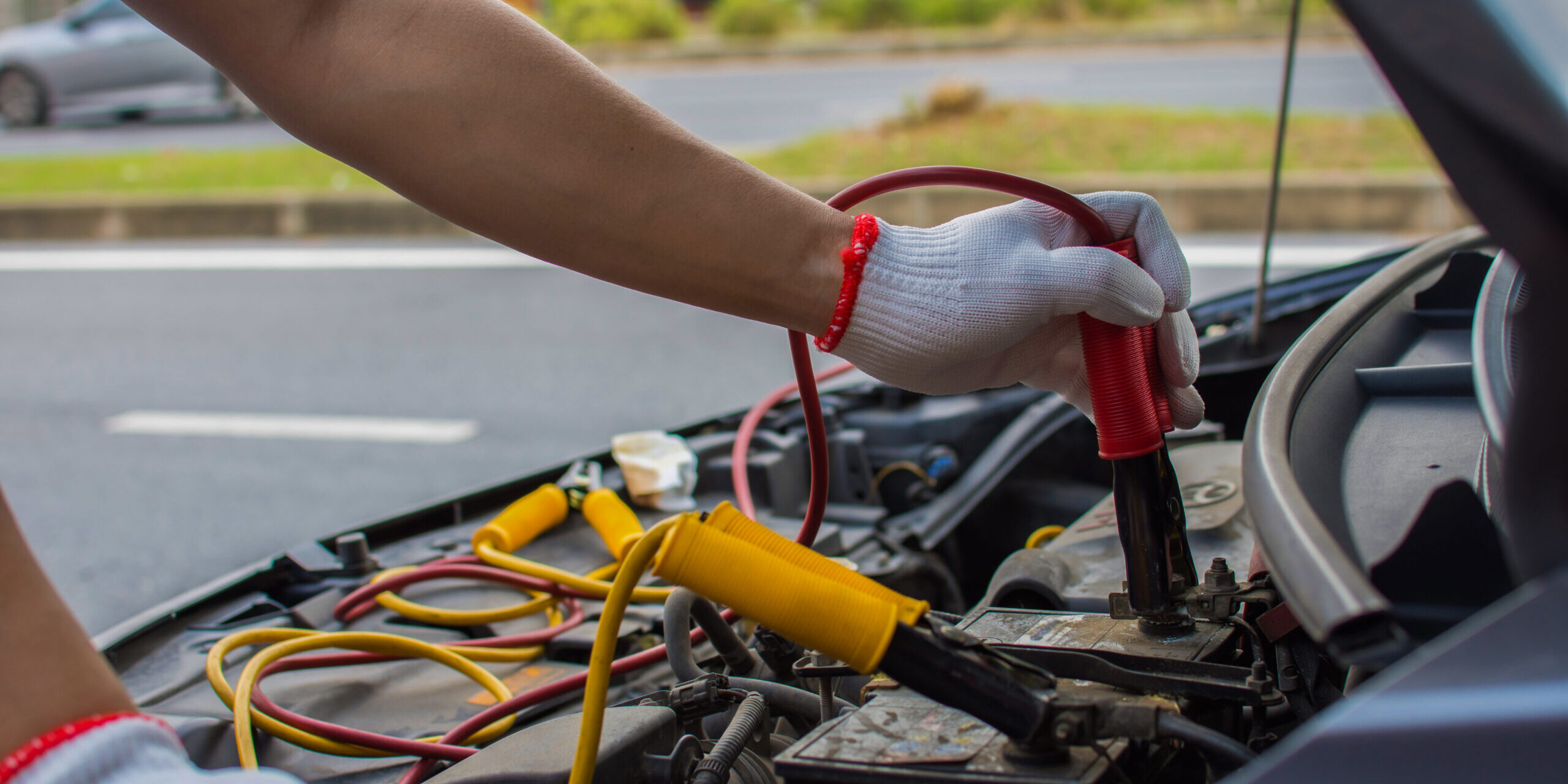 The Technician Uses A Booster Cable To Connect The Dead Battery. Electric Vehicle Battery Charging Via Jumper Cable